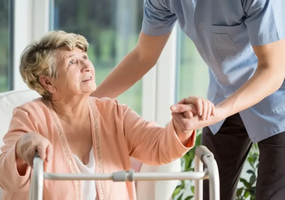 A woman in a pink shirt holding the hand of another person.